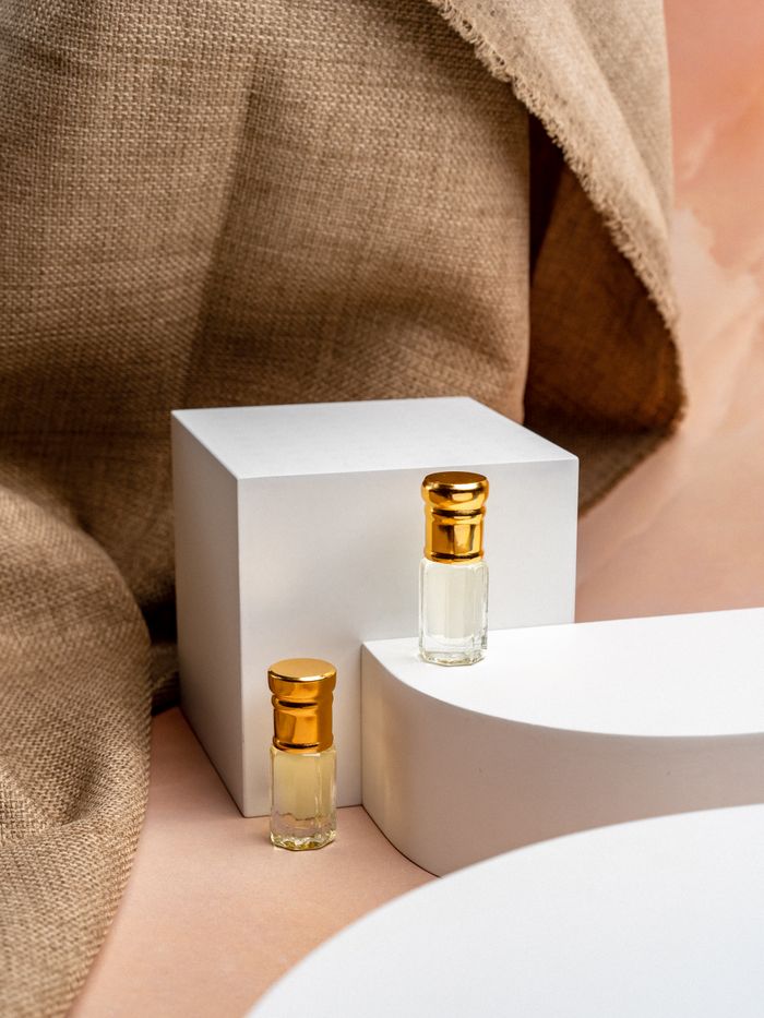 Elegant glass perfume bottles displayed on a modern minimalist setup with soft natural lighting.